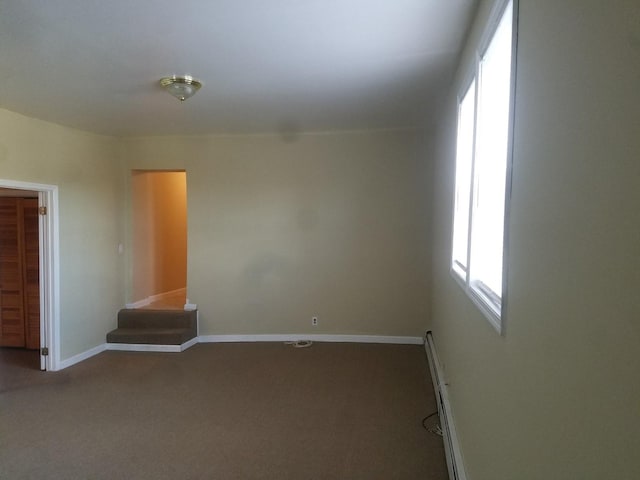 empty room with carpet floors and baseboard heating