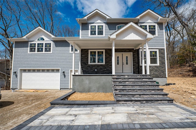 597 Pulaski, Kings Park, NY 11754 - view of front facade featuring a porch, driveway, stone siding, and a garage