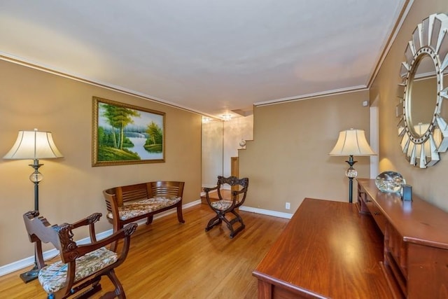 sitting room with crown molding and light wood-type flooring