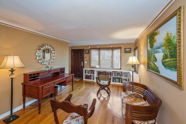 sitting room with hardwood / wood-style floors and ornamental molding