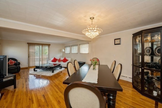 dining room with crown molding, a baseboard radiator, light hardwood / wood-style floors, and a notable chandelier