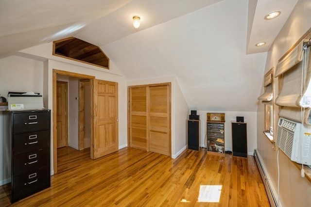 additional living space with lofted ceiling, light wood-type flooring, and baseboard heating