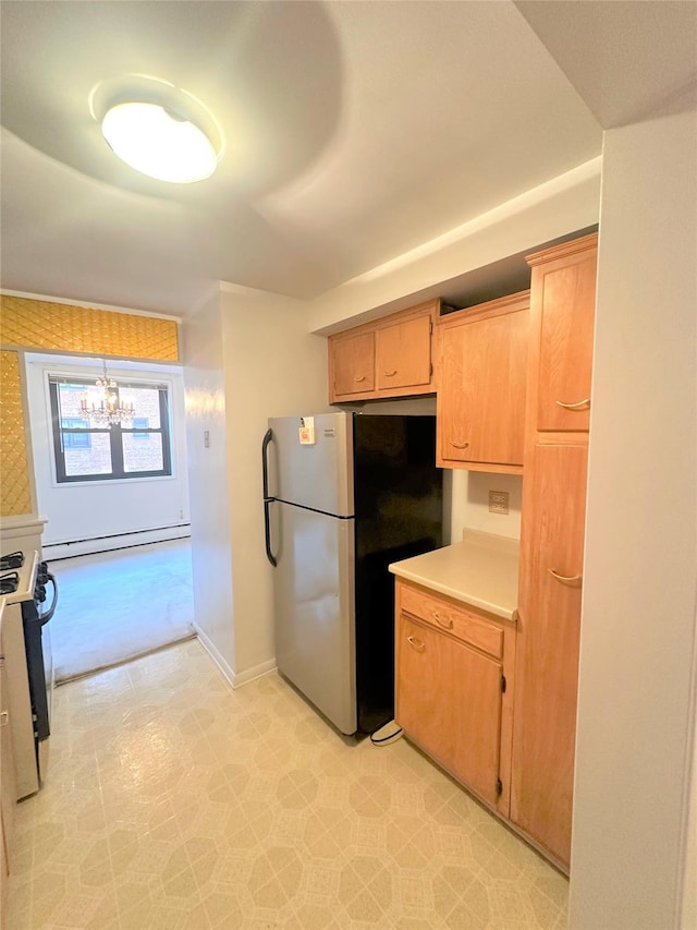 kitchen with stainless steel fridge, a baseboard heating unit, a notable chandelier, gas range, and decorative light fixtures