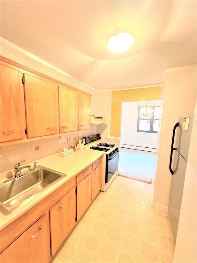 kitchen with sink, refrigerator, gas range oven, decorative backsplash, and a baseboard heating unit