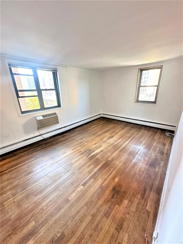 unfurnished room featuring hardwood / wood-style floors, a wealth of natural light, and baseboard heating