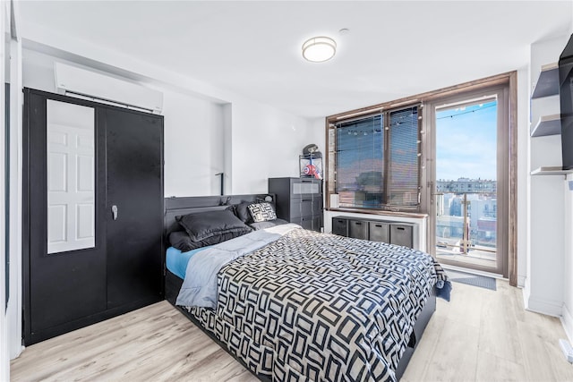 bedroom featuring a wall mounted AC and light hardwood / wood-style flooring