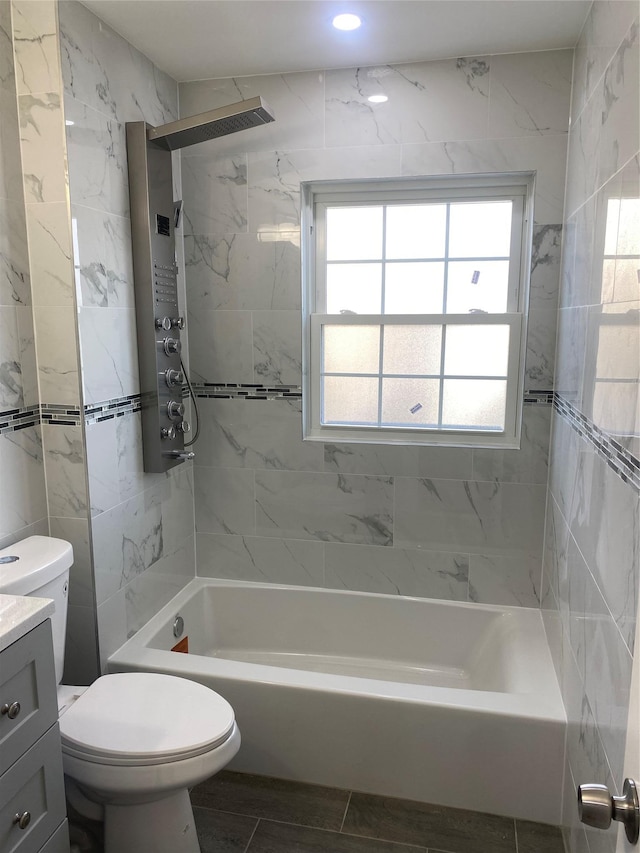 full bathroom with tiled shower / bath combo, vanity, tile walls, and toilet