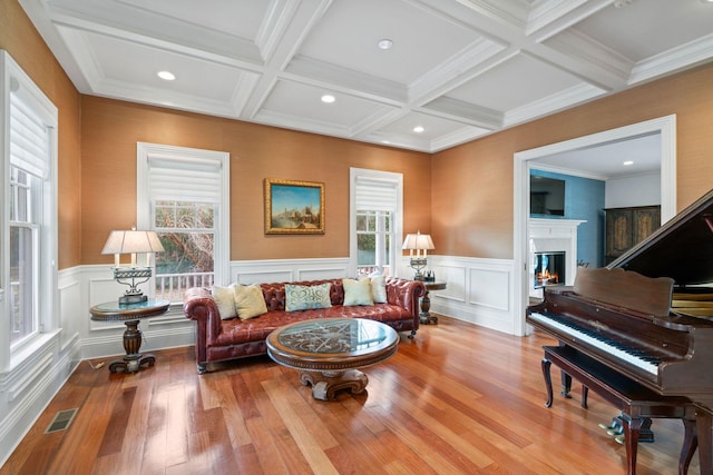 sitting room with light hardwood / wood-style flooring, a wealth of natural light, and beamed ceiling