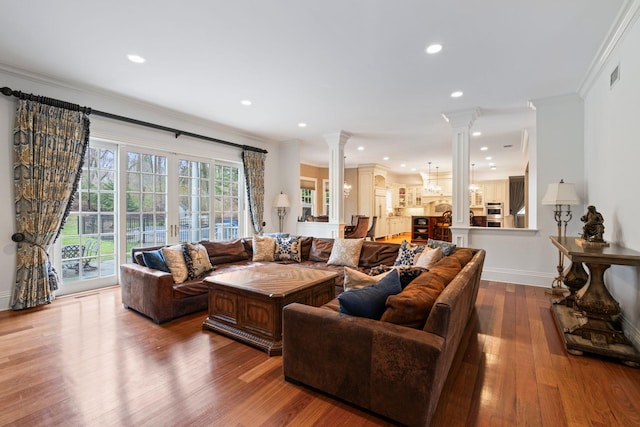 living room featuring ornamental molding, hardwood / wood-style floors, and ornate columns