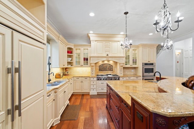 kitchen with hanging light fixtures, cream cabinets, and sink