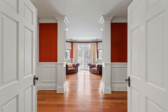 hall with crown molding and ornate columns