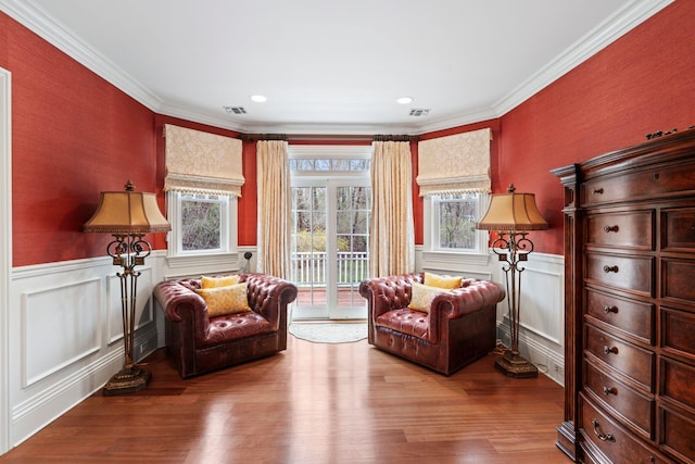 sitting room with ornamental molding and light hardwood / wood-style flooring