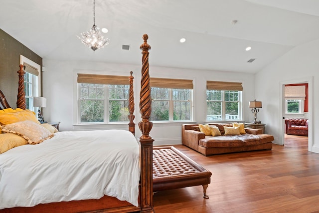 bedroom with multiple windows, hardwood / wood-style floors, and vaulted ceiling