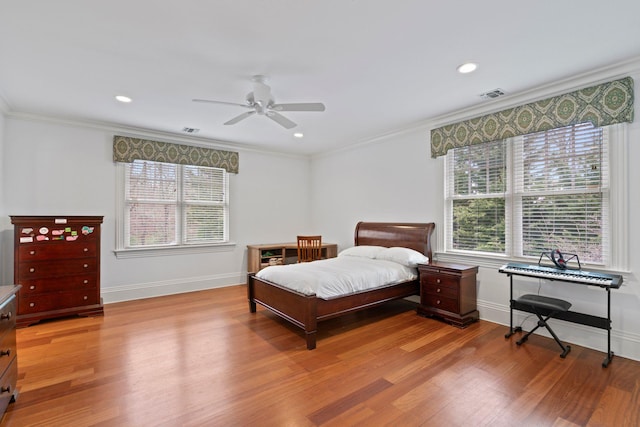 bedroom with ornamental molding, ceiling fan, and light wood-type flooring