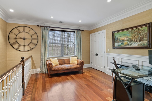 sitting room with hardwood / wood-style floors and crown molding