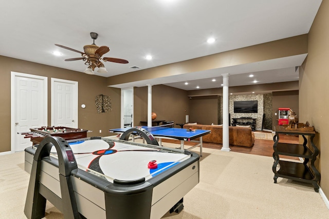 game room with light carpet, a fireplace, and ceiling fan