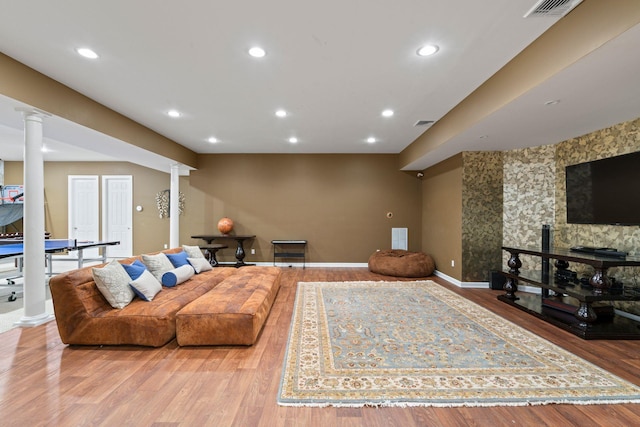 living room featuring ornate columns and light wood-type flooring