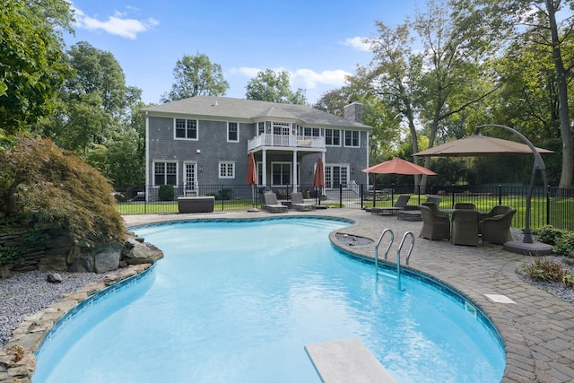 view of pool featuring a patio area and a diving board