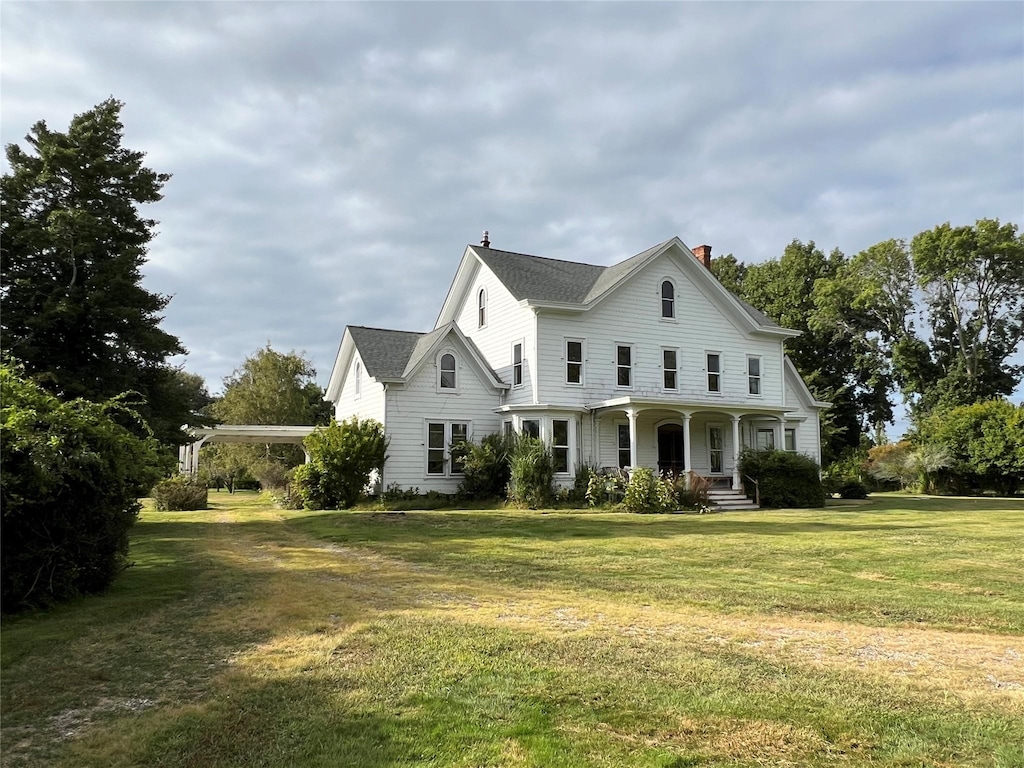 view of front of home featuring covered porch and a front lawn