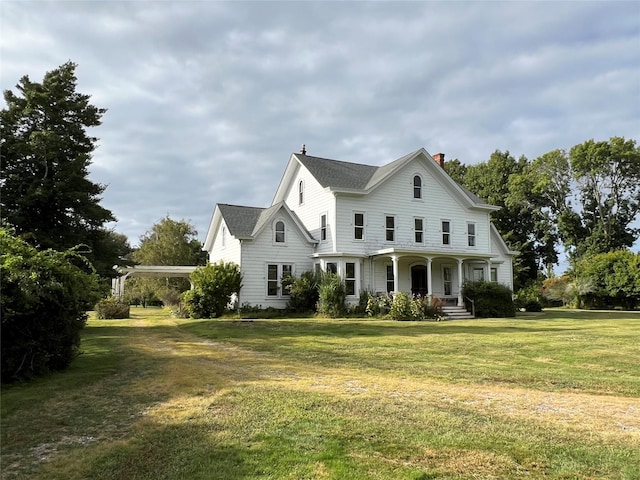 view of front of house with a porch, a chimney, and a front yard