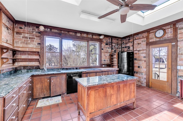 kitchen with brick wall, a sink, a kitchen island, and black appliances