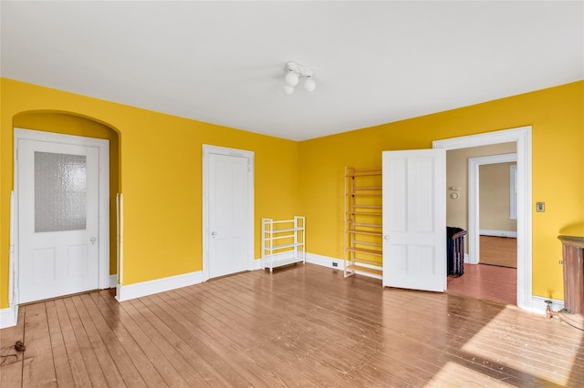 unfurnished room featuring baseboards and wood finished floors