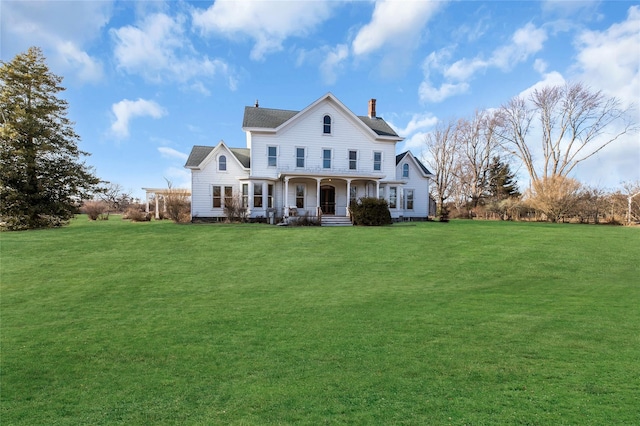 view of front of home featuring a chimney, a front lawn, and a porch