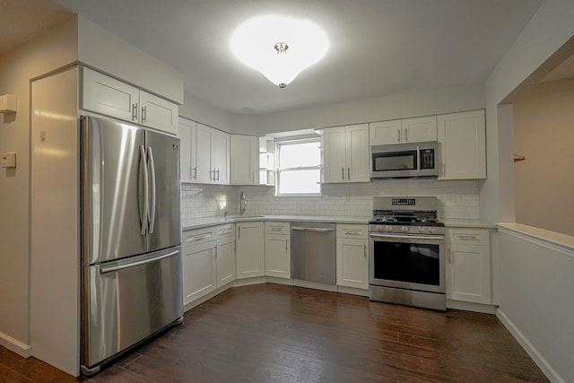 kitchen with stainless steel appliances, sink, white cabinets, and dark hardwood / wood-style floors