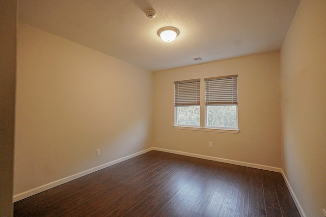 spare room with dark hardwood / wood-style flooring