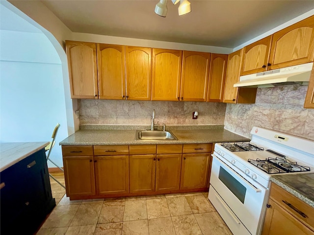 kitchen with tasteful backsplash, sink, and gas range gas stove