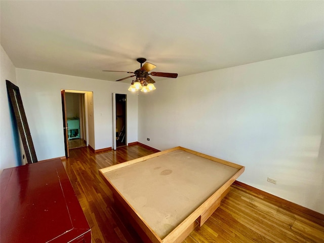 unfurnished bedroom featuring dark hardwood / wood-style floors and ceiling fan