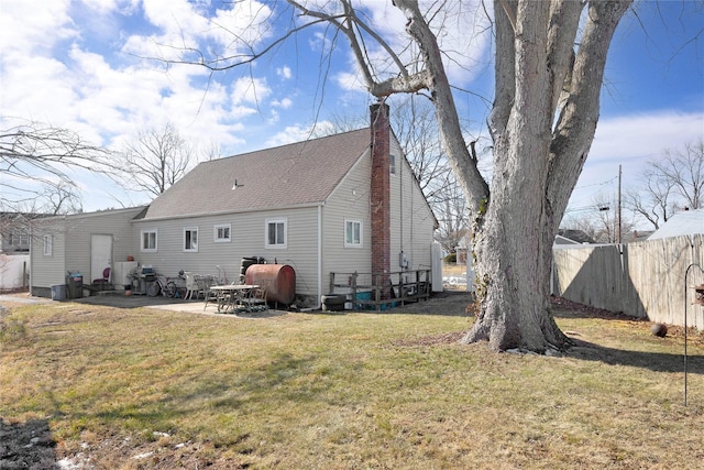 rear view of property featuring a yard and a patio area