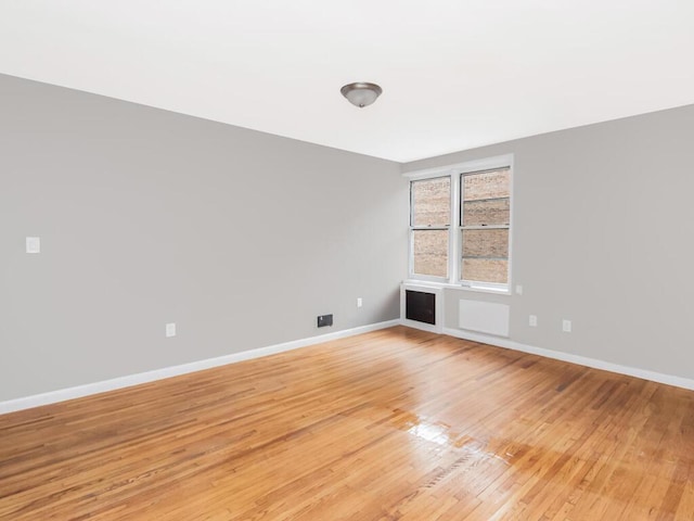 spare room featuring light wood-type flooring and baseboards