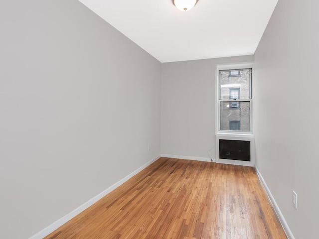 empty room featuring baseboards and light wood finished floors