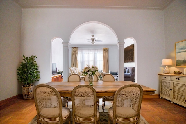 dining space featuring ornate columns, parquet flooring, and ceiling fan