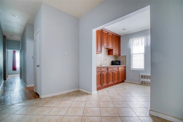 kitchen featuring tasteful backsplash, light tile patterned floors, and sink