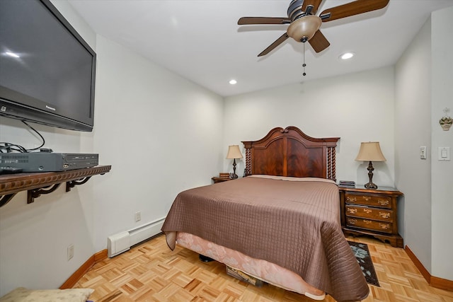 bedroom with light parquet floors, a baseboard heating unit, and ceiling fan