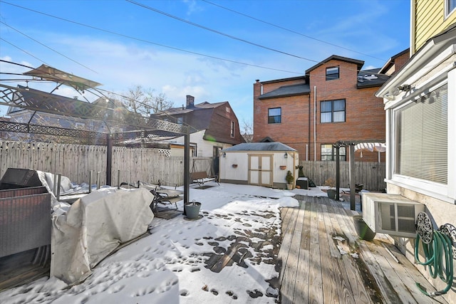 snow covered deck with a storage unit