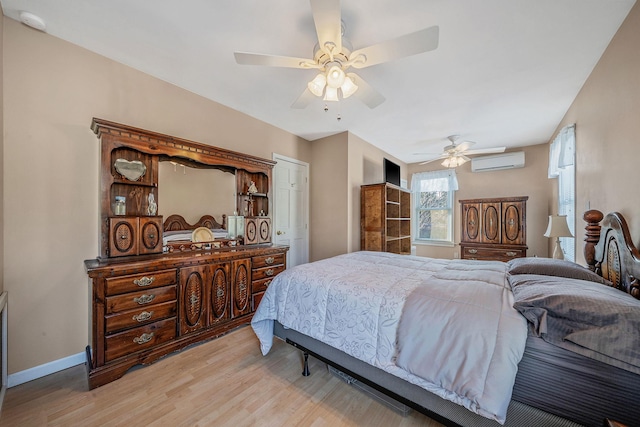 bedroom featuring ceiling fan, a wall mounted air conditioner, and light wood-type flooring