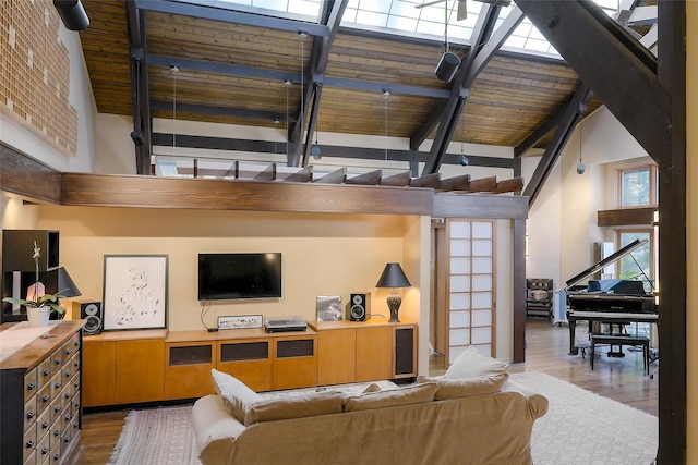 living room with wood-type flooring, high vaulted ceiling, and beamed ceiling