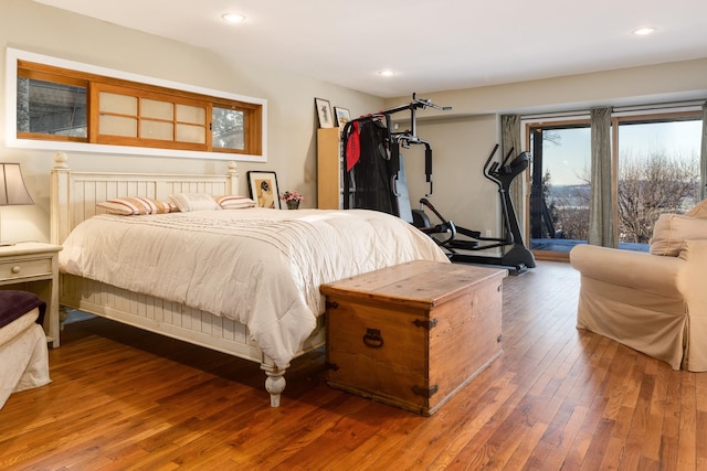 bedroom with access to exterior and hardwood / wood-style floors