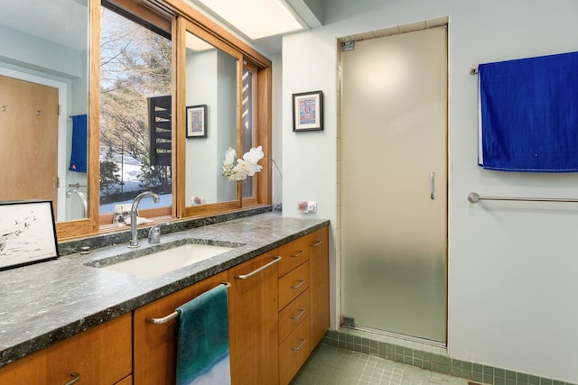 bathroom featuring vanity, tile patterned flooring, a shower with door, and a healthy amount of sunlight