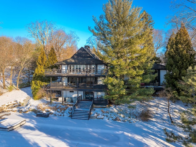 snow covered house featuring a deck