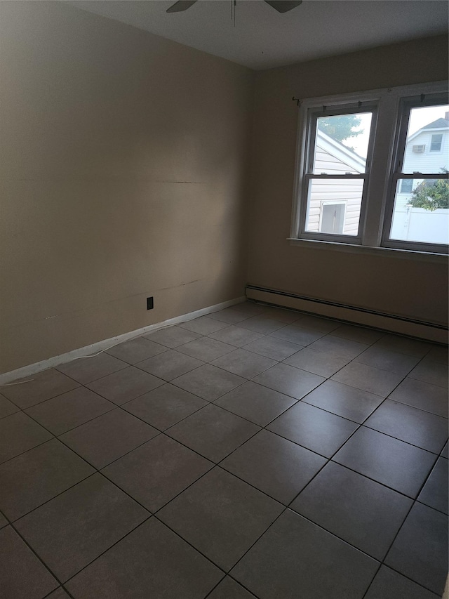 unfurnished room with ceiling fan, a baseboard radiator, plenty of natural light, and tile patterned floors