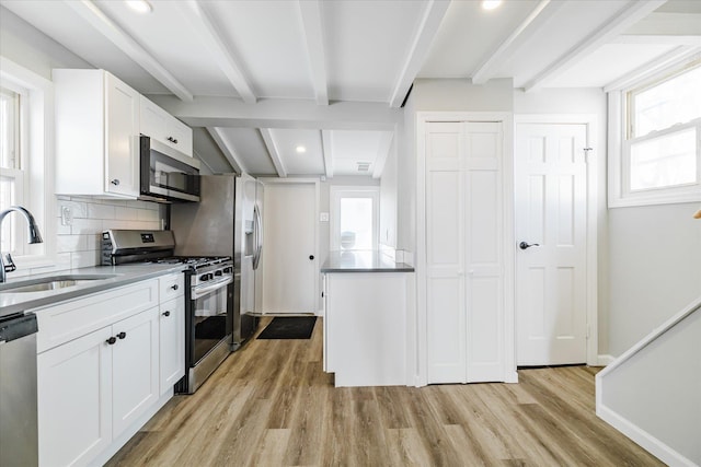 kitchen with tasteful backsplash, sink, white cabinets, stainless steel appliances, and beam ceiling