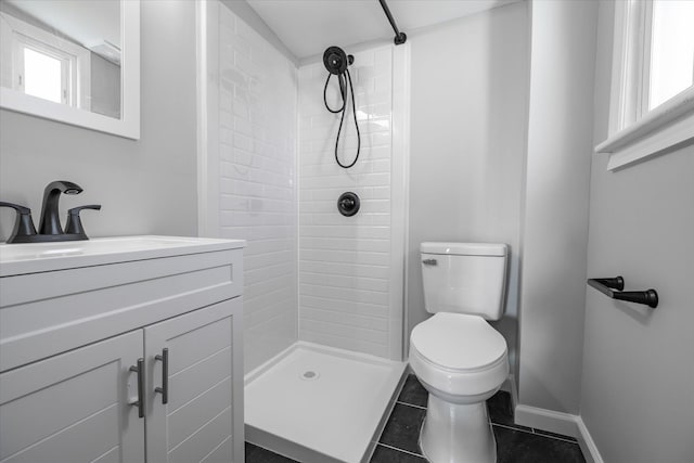 bathroom with vanity, tiled shower, tile patterned floors, and toilet