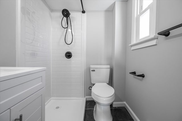 bathroom with tile patterned flooring, a tile shower, and toilet