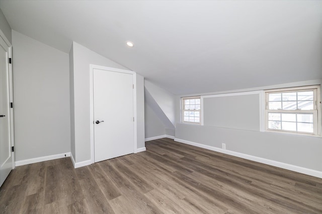 additional living space featuring lofted ceiling and dark hardwood / wood-style floors