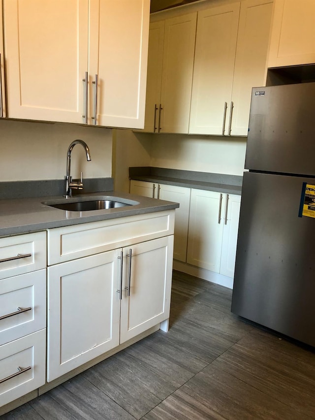 kitchen featuring sink, stainless steel fridge, dark hardwood / wood-style floors, and white cabinets