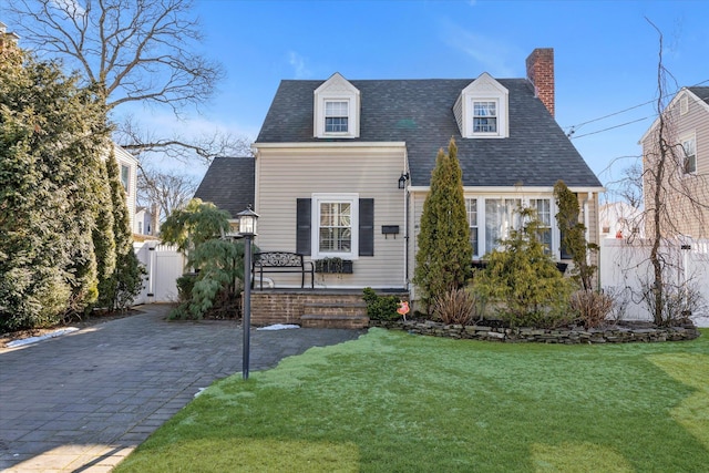 cape cod house featuring a front yard